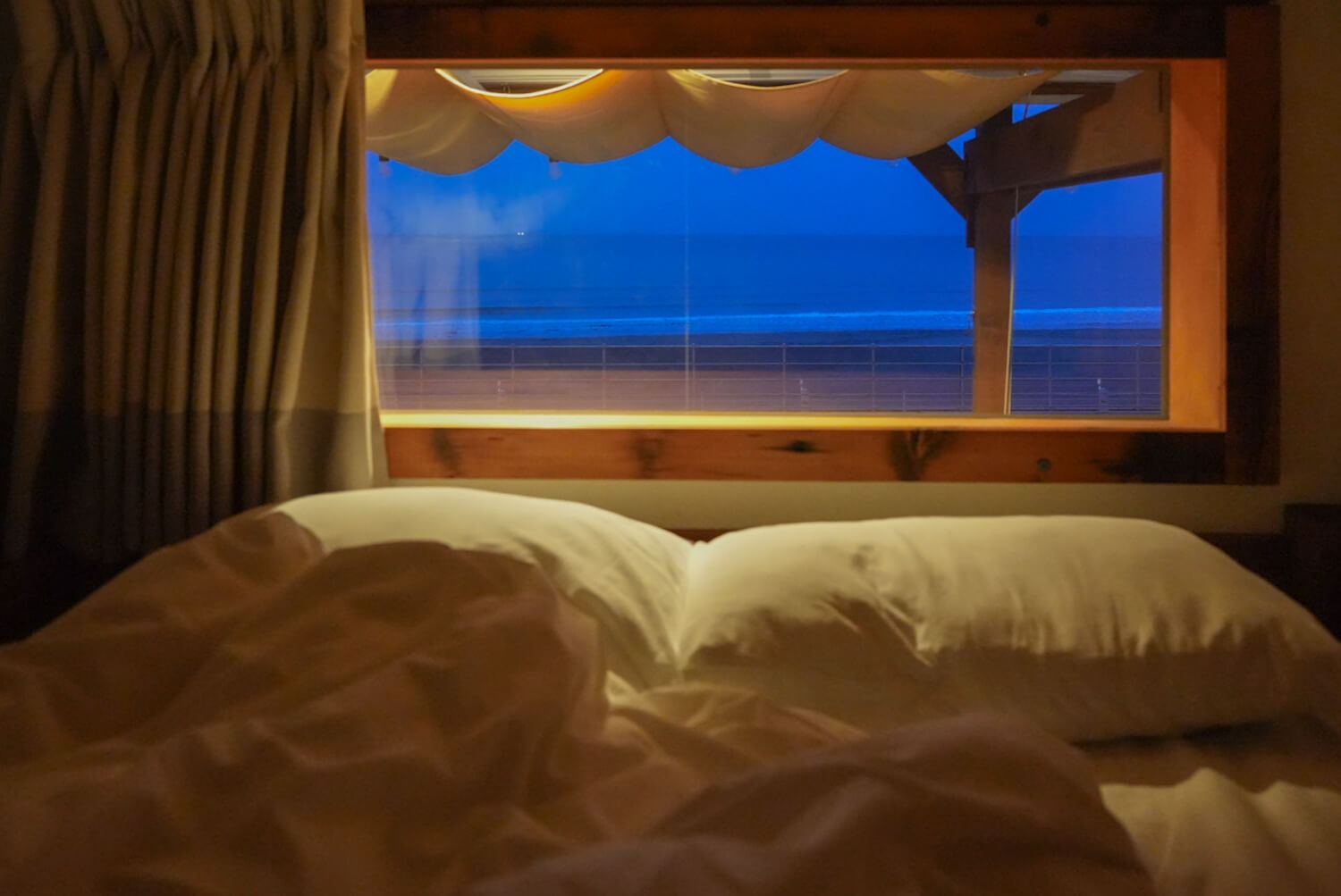 ベッド越しの夜明け前の海